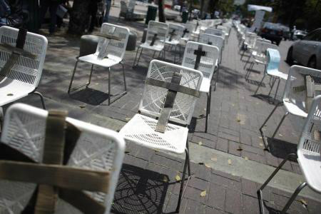 Manifestantes contrários ao governo colocam cruzes pretas em cadeiras brancas para representar vítimas que morreram em atos violentos, em Caracas, na Venezuela, em março.