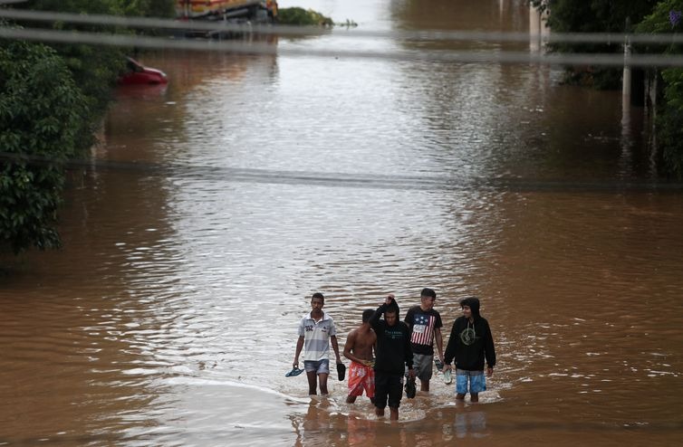 Moradores caminham pela água que inundou rua na Vila Prudente, em São Paulo / Foto: Amanda Perobelli/Reuters/Direitos reservados