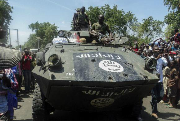 Soldados nigerianos exibem tanque capturado do grupo Boko Haram ao entrar na cidade de Maiduguri, NigeriaAgência Lusa/EPA/Tony Nwosu