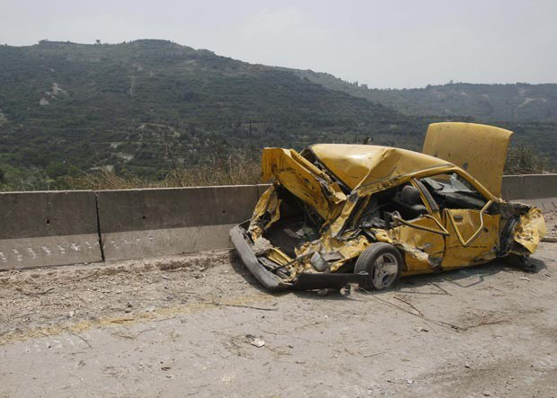 Carro destruído em Haffeh nesta quinta-feira (14), após a cidade ter sido bombardeada por forças sírias (Foto: AFP)