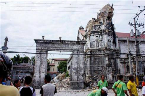 Filipinos observam a histórica Igreja do Santo Menino destruída nesta terça-feira por um terremoto de 7,2 graus na cidade de Cebu. EFE