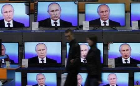 Presidente russo, Vladimir Putin, aparece em TVs dispostas na vitrine de uma loja de Krasnoyarsk, na Sibéria, Rússia.