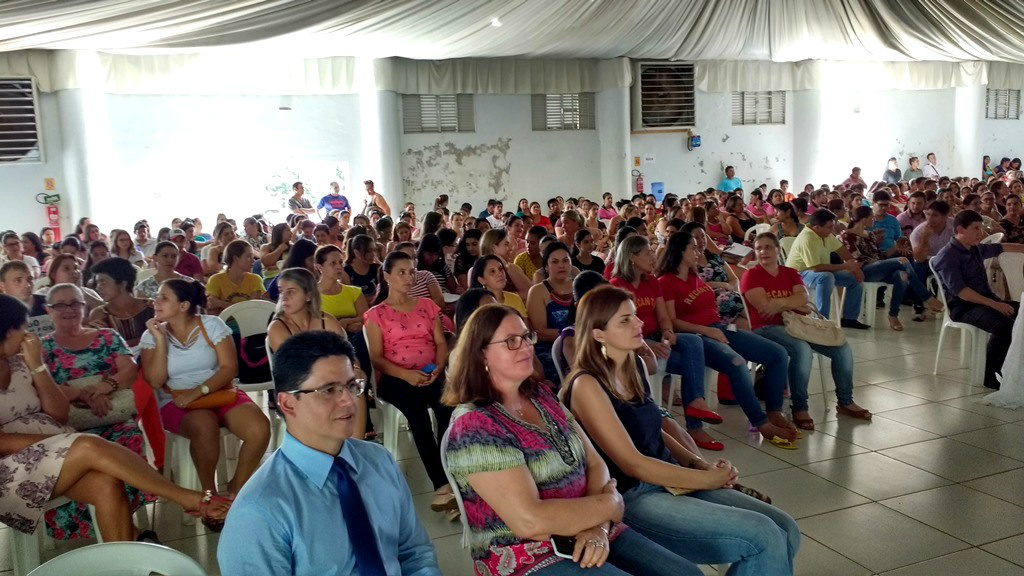 Auditório lotado por profissionais da Educação de Amambai; em primeiro plano, o defensor Marcelo Marinho, a secretária municipal de Educação, Zita Centenaro, e a professora da equipe de projetos da Semed, Glauce Mascarenhas.