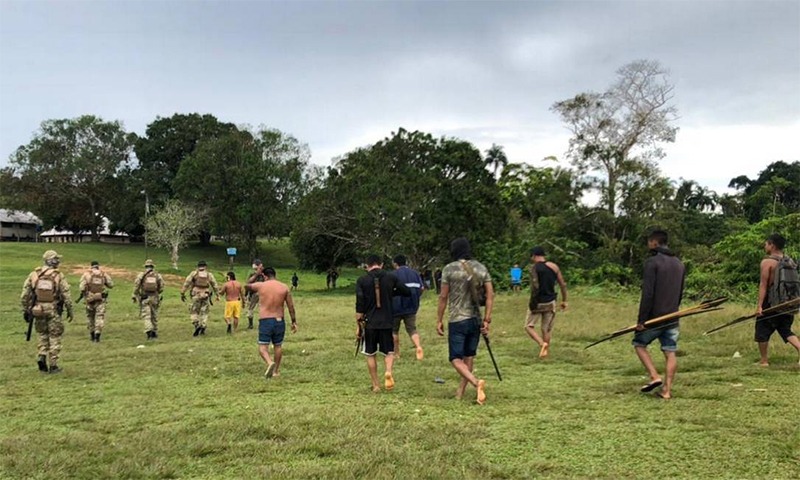 Como o PCC se infiltrou nos garimpos em Roraima Indígenas e agentes da PF na aldeia Palimi ú (Foto: Polícia Federal).
