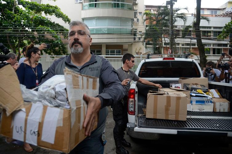 Policiais carregam caixas apreendidas em endereço ligado a suspeito de matar a vereadora Marielle Franco e o motorista Anderson Gomes - Tânia Rêgo/Agência Brasil