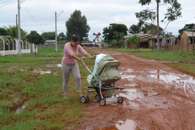 Moradora da vila Jardim Panorama, Lilian Zorrilha enfrenta o barro das ruas da vila Cristina para visitar a casa de sua mãe. Foto: Moreira Produções.