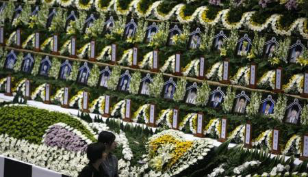 Retratos das vítimas a bordo da barca naufragada Sewol são colocados entre flores em um altar temporário montado em Ansan, na Coreia do Sul.