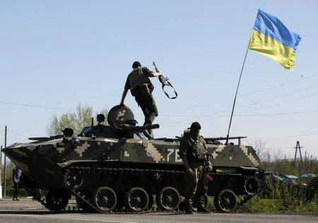 Um soldado ucraniano pula de um veículo blindado de transporte de pessoal em um posto de controle na vila de Malinivka. 
