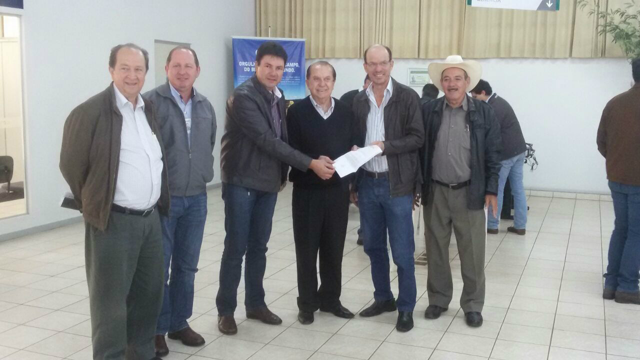 Sergio Barbosa e Jaime Bambil durante a entrega do documento a José Aroldo Gallassini, acompanhado pelo presidente da unidade de Amambai, Walmir Flávio Ritter, e cooperados.