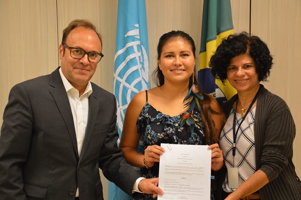 Fundo de População da ONU apoia articulação da juventude indígena no Brasil Representante do UNFPA no Brasil, Jaime Nadal, ao lado da integrante da REJUIND, Rayanne França, e de profissional do Instituto Autonomia, durante assinatura de acordo em Brasília. Foto: UNFPA Brasil