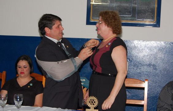 Rotary e Rotaract Clubs de Amambai empossam novas presidentes Rosevalde Arruda do Amaral passa o distintivo de presidente do Rotary Club para Viviane Viaut Moreira, que assumirá a presidência do clube no ano rotário de 2012/2013. Foto: Moreira Produções.