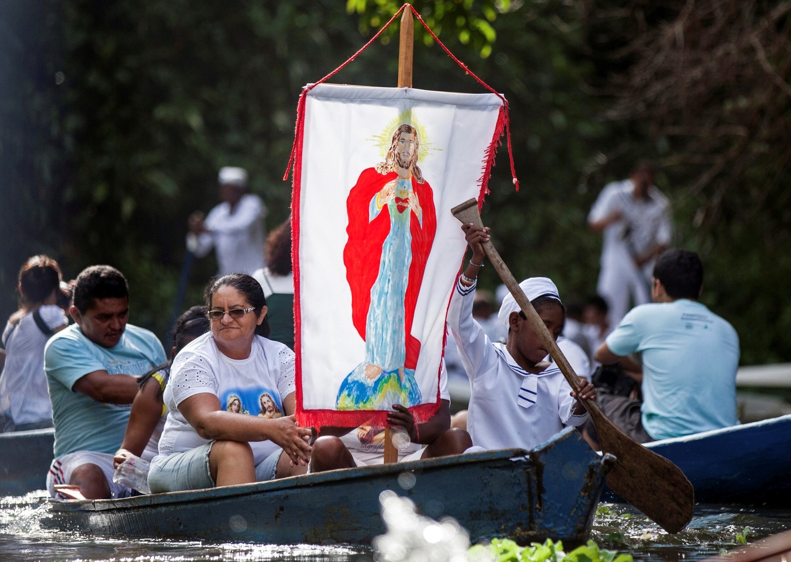 Vaticano cogita permitir que homens casados se tornem padres na Amazônia Peregrinos católicos exibem faixa com uma imagem de Jesus durante uma viagem de barco em Santa Izabel do Pará, no Pará, em 2012. — Foto: Paulo Santos/Arquivo/Reuters