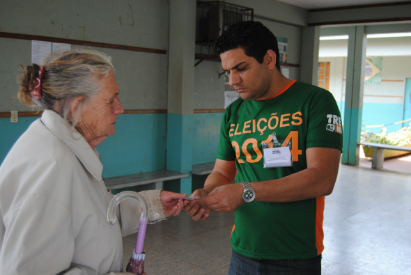 Servidor público Luciano de Souza repassando informações para eleitora / Foto: Moreira Produções