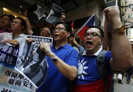 Manifestantes rasgam foto do presidente do Vietnã, Truong Tan Sang, durante protesto em frente ao consulado vietnamita em Hong Kong.