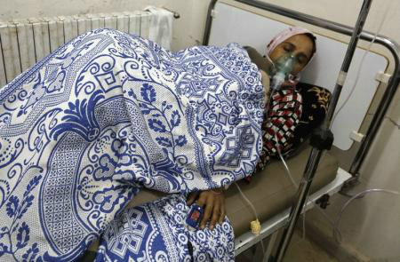 Mulher afetada pelo que ativistas disseram ter sido um ataque com gás cloro recebe tratamento em um hospital de campanha de Hama, na Síria.