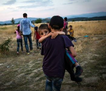 Sérvia deve continuar recebendo cerca de três mil migrantes por dia Menino sírio carrega irmão ao cruzarem fronteira. Foto: Acnur/A. McConnel