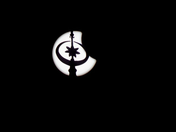 Minarete é visto junto ao eclipse total do Sol nesta sexta-feira (20) e, Eger, na Hungria (Foto: Peter Komka/MTI/AP)