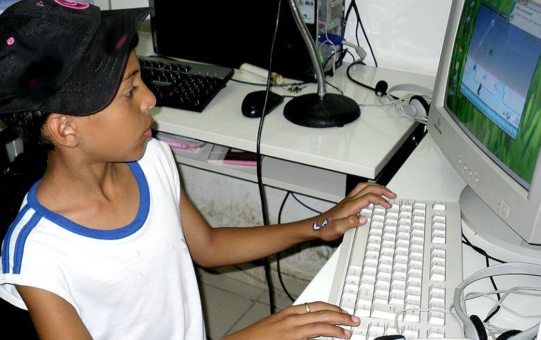 Estudante de escola pública acessa a internet em equipamento instalado na escola: renda maior das famílias e inclusão social
