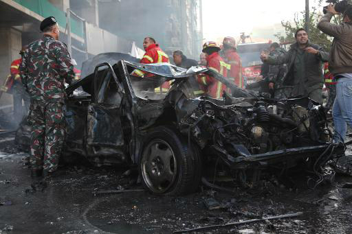 Forças de segurança ao redor de carro destruído em atentado em Beirute (AFP)