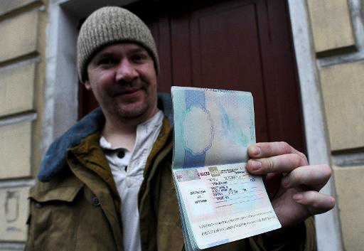 Ativista do Greenpeace Anthony Perrett mostra seu passaporte com o visto russo em São Petersburgo
