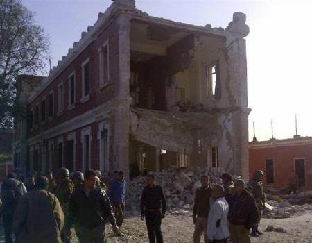Pessoas e militares em volta de um edifício danificado após uma explosão na região do Delta do Nilo. 