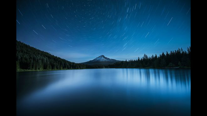 Polaris over Mount Hood de Garrett SuhrieA Estrela do Norte, Polaris, aparece alinhada com o Mount Hood, no Oregon (EUA), e o lago Trillium. O fotógrafo usou exposição de 20 minutos para criar rastros de estrelas mapeando a rotação da Terra. Foto: Garrett Suhrie