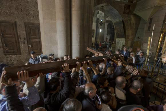 Cristãos carregam cruz de madeira na Igreja do Santo Sepulcro, em Jerusalém, durante procissão da Via Sacra na Sexta-feira Santa - Jim Hollander/EPA/Agência Lusa
