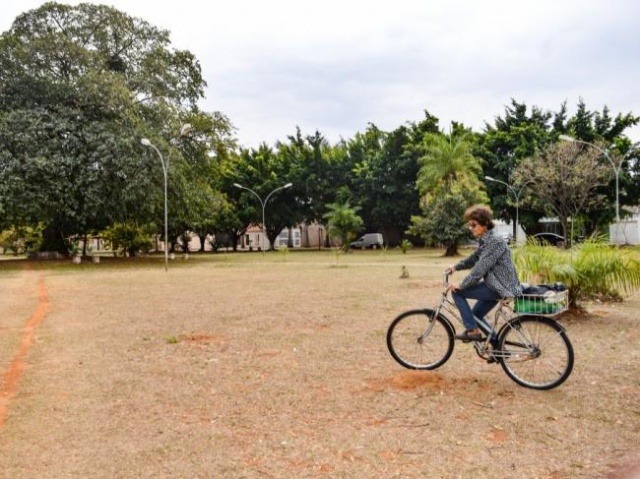 Há 20 anos, Josi acorda cedo e pedala 14 quadras para regar plantas em praça Em sua bicicleta, Josi carrega as garrafas com água (Foto: Alana Portela)