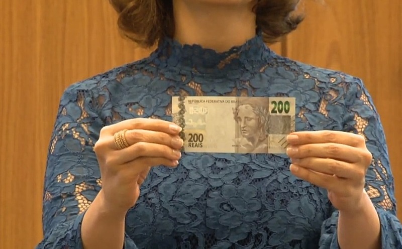 Nota de R$ 200 começa a circular; entenda os motivos e as polêmicas A diretora de Administração do BC, Carolina de Assis Barros, exibe a nota de R$ 200 - Reprodução