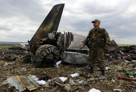 Separatista armado pró-Rússia no local da queda de um avião do Exército ucraniano em Luhansk, no leste da Ucrânia, neste sábado. 14/06/2014
