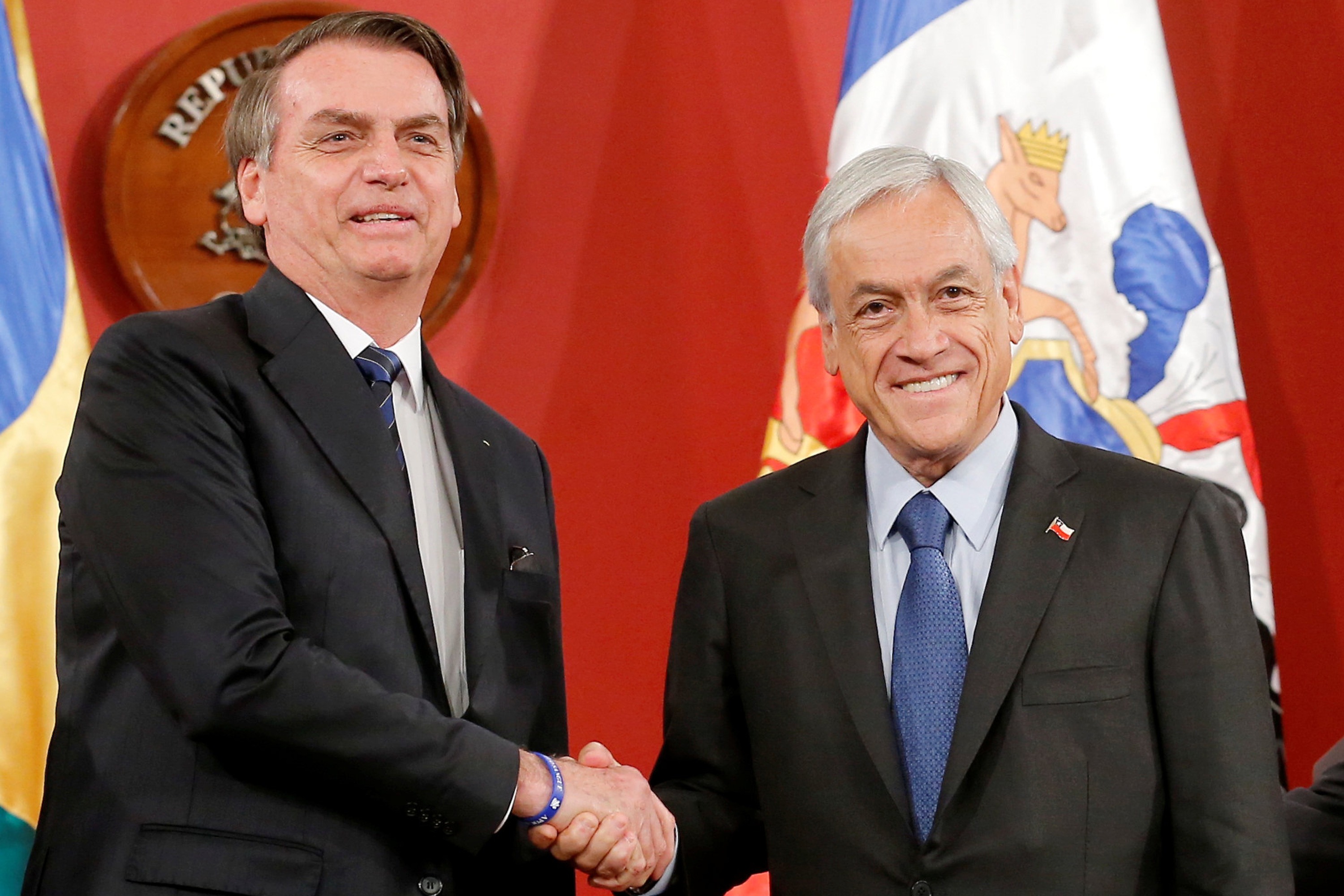 Brasil e Chile querem aproximar Mercosul e Aliança do Pacífico O presidente da República, Jair Bolsonaro, cumprimenta o presidente chileno Sebastián Piñera, durante assinatura de acordos em Santiago- 23/03/2019 (Rodrigo Garrido/Reuters)