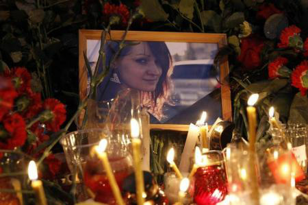 Retrato de vítima repousa em meio a flores e velas no local de uma explosão em trólei em Volgogrado
