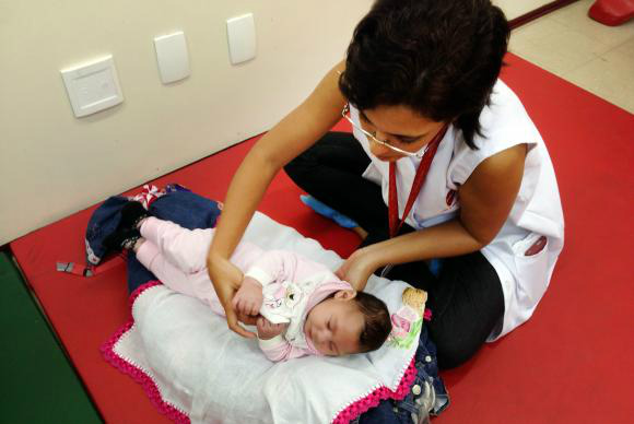 Exercícios simples estimulam o desenvolvimento de bebês com microcefalia Recife - A fisioterapeuta Cynthia Ximenes da Associação de Assistência à Criança Deficiente estimula a pequena Maria Vitória que tem microcefalia Sumaia Villela/Agência Brasil