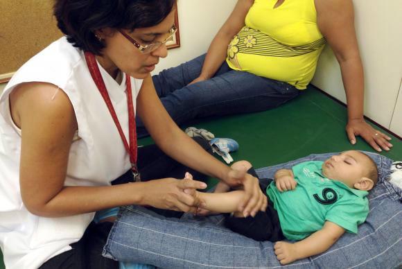 Exercícios simples estimulam o desenvolvimento de bebês com microcefalia Recife - João Miguel, de 4 meses, faz a primeira sessão de estimulação precoce com a fisioterapeuta Cynthia Ximenes, na Associação de Assistência à Criança Deficiente (AACD), que atende bebês com microcefalia e orienta as mães sobre como repetir os exercícios em casa para melhorar o desenvolvimento das criançasSumaia Villela/Agência Brasil
