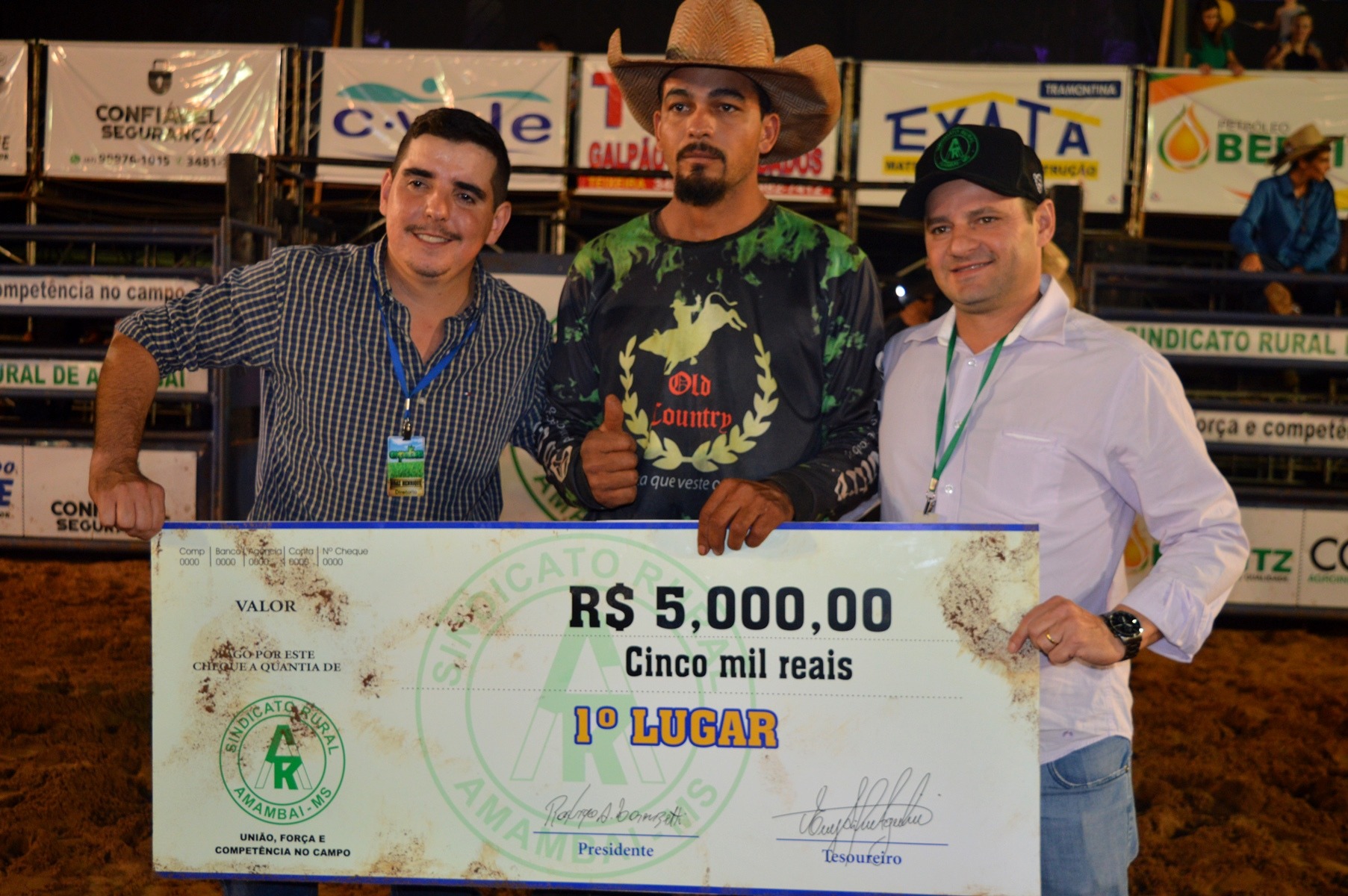 Após dois anos fora das arenas, peão de Tacuru é campeão do rodeio na Expobai E/D: Braz Henrique, diretor de rodeios da Expobai, o peão vencedor do certame e Rodrigo Lorenszetti, presidente do Sindicato Rural de Amambai / Foto: Moreira Produções