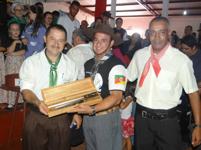 Ganhadores do concurso de melhor arroz carreteiro recebendo o prêmio das mãos do patrão do CTG José Adão/ Foto: Moreira Produções