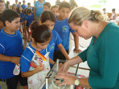 Servidora da secretaria de Saúde mostra aos alunos larvas e o  mosquito da dengue.