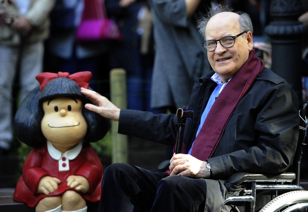 Quino, cartunista argentino criador de Mafalda, morre aos 88 anos O cartunista Joaquin Salvador Lavado, também conhecido como Quino, posa ao lado de uma escultura de sua personagem Mafalda, em Oviedo, na Espanha. Foto de outubro de 2014 — Foto: Miguel Riopa/AFP/Arquivo
