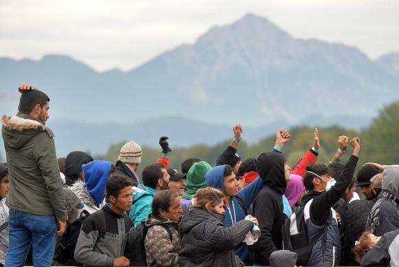 Refugiados esperam para atravessar a fronteira a partir de Salzburgo na Áustria para Freilassing na AlemanhaEPA/Barbara Gindl/Agência Lusa/Direitos Reservados