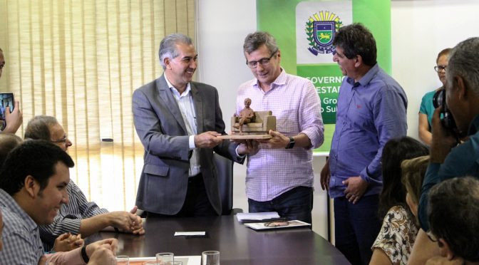 Nos 101 anos do poeta, Governo do Estado inaugura estátua de Manoel de Barros Governador recebendo uma réplica, em miniatura, da estátua original que será inaugurada nesta terça-feira / Foto: Divulgação