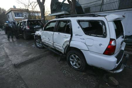 Polciais afegãos inspecionam veículos danificados em frente a um restaurante libanês, local de um ataque suicida, em Cabul.