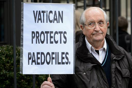 Homem segura placa durante um protesto contra o Vaticano, do lado de fora da sede dComissão de Direitos Humanos da ONU, em Genebra (AFP, FABRICE COFFRINI)
