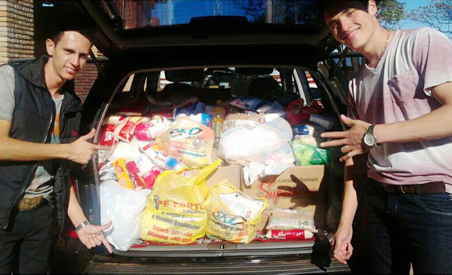 Dupla junto com os alimentos arrecadados.