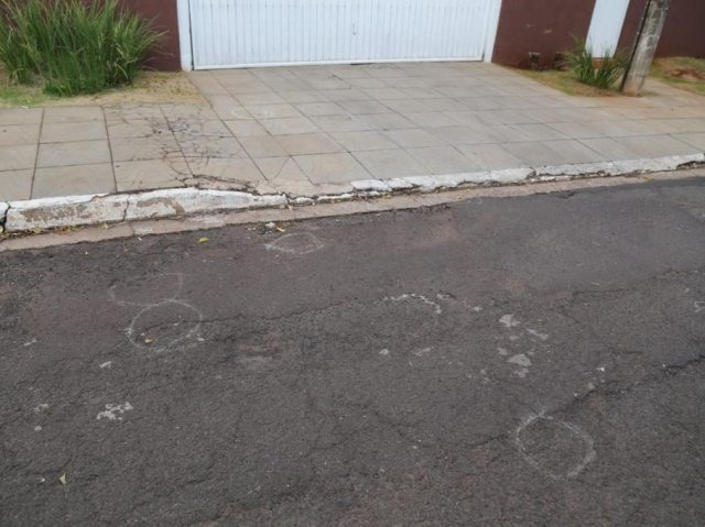 Marcas no asfalto indicam a quantidade de munições encontradas em frente à casa (Foto: Paulo Francis) 