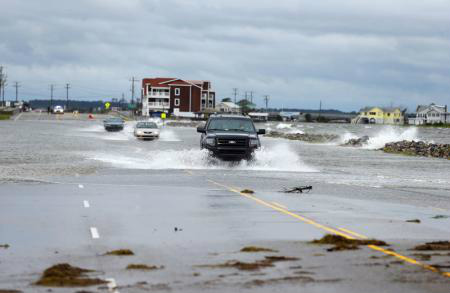 Carros cruzam uma avenida alagada após a passagem do furacão Arthur em Nags Head, na Carolina do Norte, Estados Unidos, nesta sexta-feira. 04/07/2014