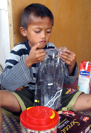 O menino Ilham, de 8 anos, é visto brincando em suacasa em Bogor (Foto: AFP/Komnas Perlingdungan)