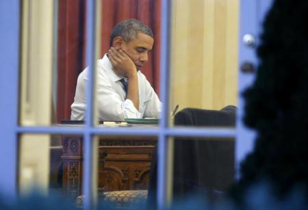 Presidente dos EUA, Barack Obama, fotografado dentro do Salão Oval, na Casa Branca, na noite anterior ao dia em que ele fará o pronunciamento do Estado da Nação, em Washington.