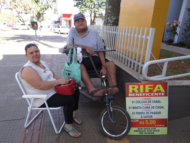 O cadeirante e sua esposa passam o dia frente ao Banco do Brasil.