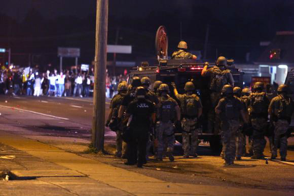 Polícia tenta dispersar manifestantes que continuam os protestos contra o assassinato de Michael Brown ED ZURGA