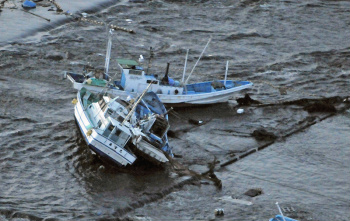 Barcos pesqueiros foram levados pela força das ondas de tsunami no Japão  Kyodo News/AP Photo